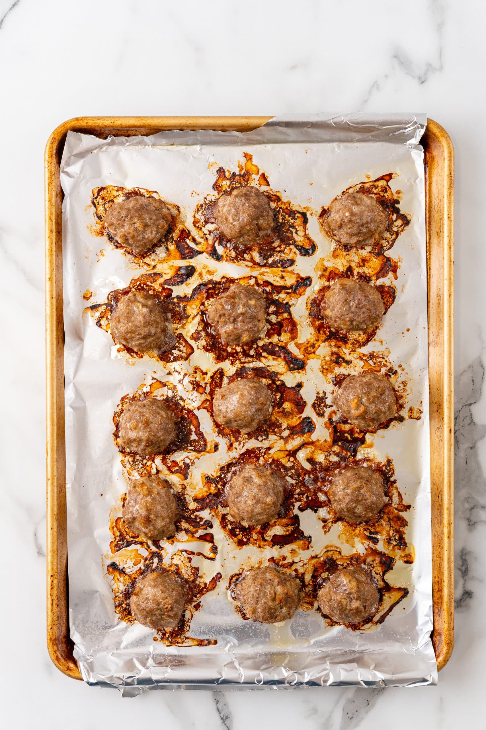 crispy baked stuffing meatballs arranged in rows on a foil lined baking sheet