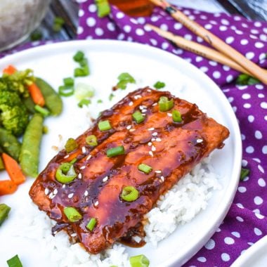 honey sriracha salmon over white rice on a white plate