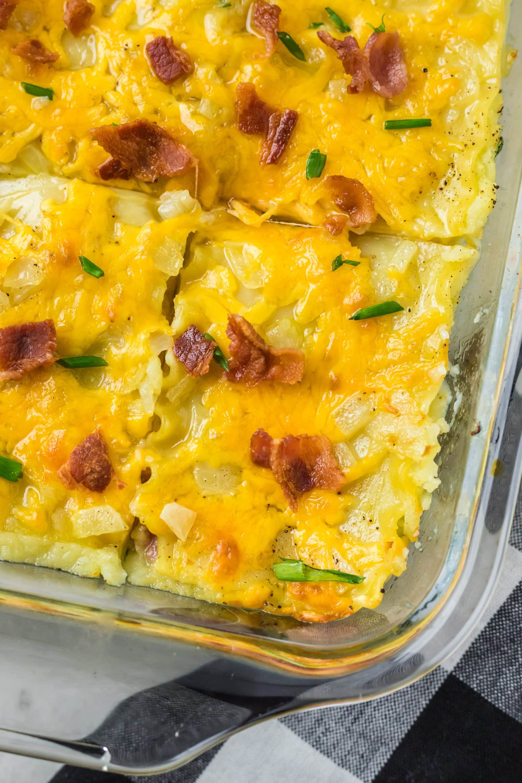 a bacon topped pierogi lasagna in a large glass baking dish