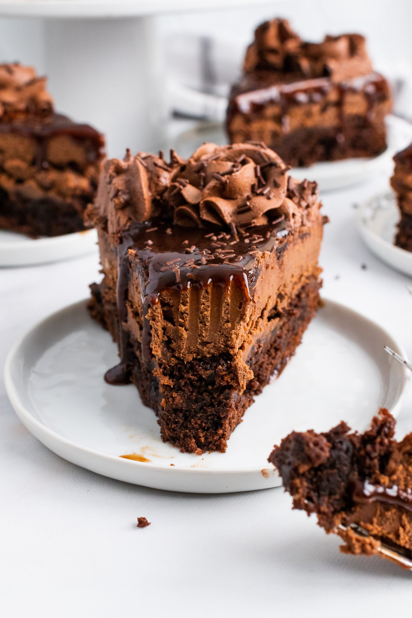 a single slice of fudge brownie cheesecake on a small white plate