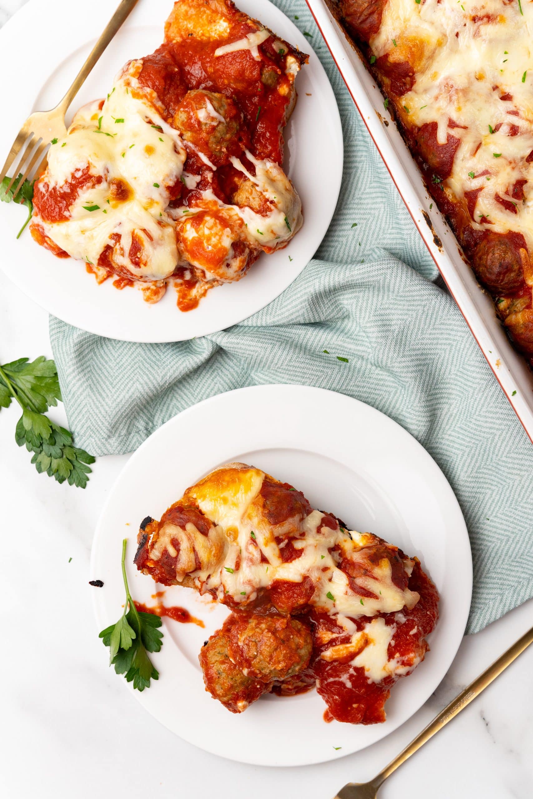 slices of meatball sub casserole on two small white plates