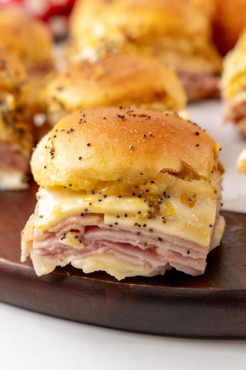 hot ham and cheese sliders on a wooden cutting board