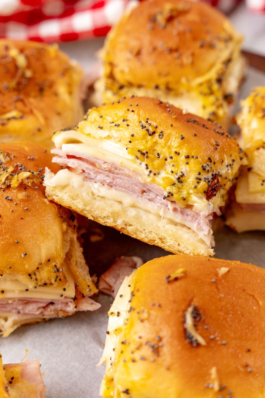 hot ham and cheese sliders on a wooden cutting board