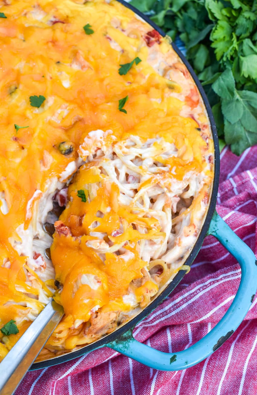 a silver spoon in a skillet filled with creamy chicken spaghetti